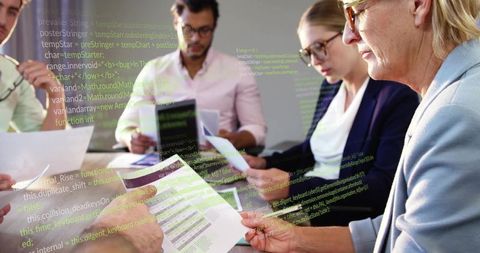 Executives reviewing reports with code overlay, collaborating on data analytics strategy