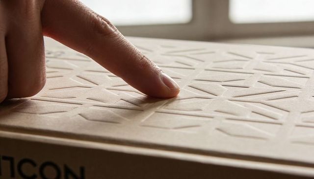 Finger Pressing Embossed Kraft Box Lid with Geometric Pattern Close-Up in Daylight