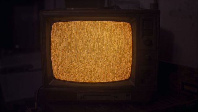 Amber Static on Vintage CRT TV in Dimly Lit Basement Scene