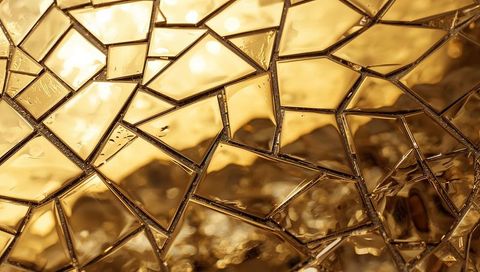 Golden cracked glass mosaic reflecting warm backlight with geometric shards and droplets
