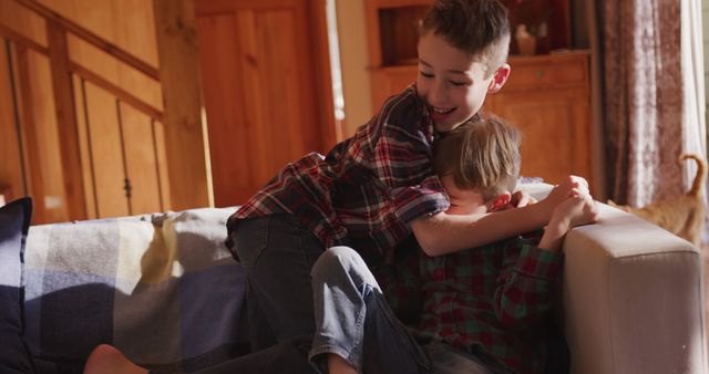 Siblings Playfully Wrestling on Couch in Cozy Living Room - Download Free Stock Images Pikwizard.com