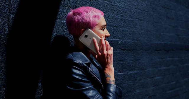 Woman with Pink Hair Talking on Smartphone Against Dark Wall - Download Free Stock Images Pikwizard.com