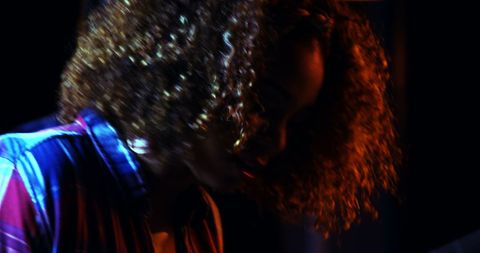 Musician playing in dimly lit studio with dramatic lighting