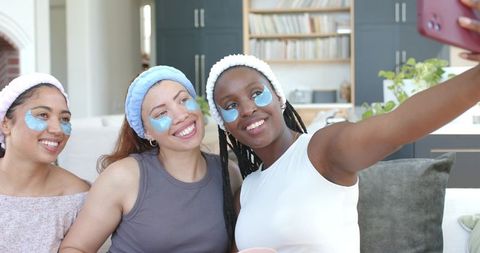 African american women taking selfie during at-home spa day with hydrogel eye patches