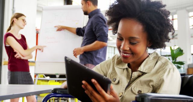 African American Woman in Wheelchair Using Tablet in Office Meeting - Download Free Stock Images Pikwizard.com