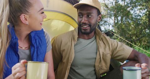 Diverse Couple Enjoying Camping in Nature with Hot Beverages