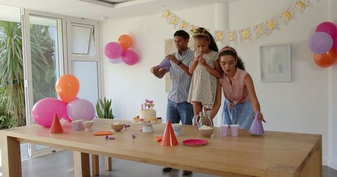Family preparing birthday party in festively decorated room