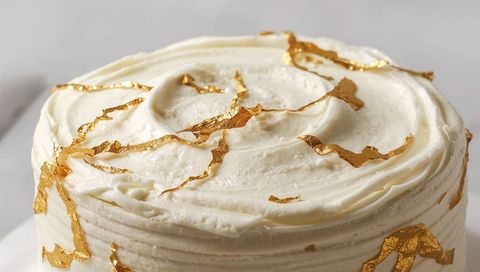 Elegant White Buttercream Cake Featuring Edible Gold Leaf Swirl Decoration