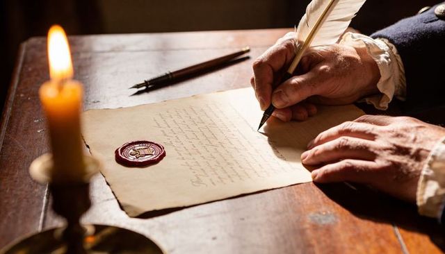 Historic scribe writing parchment with quill and wax seal by candlelight, period clothing