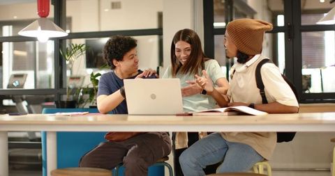 Young African American Coworkers Collaborating Around Laptop in Modern Coworking Space
