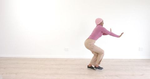 Energetic woman practicing dance moves in bright studio