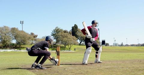 Cricket Match with Opponents on Grassy Field
