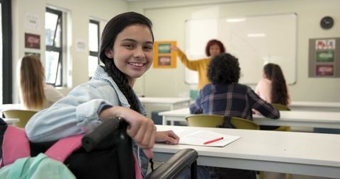 Hispanic teen in wheelchair engaging in inclusive classroom