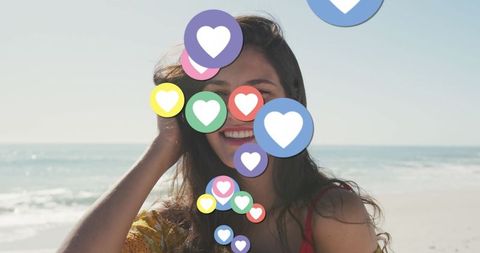 Smiling Woman on Beach Surrounded by Digital Heart Icons