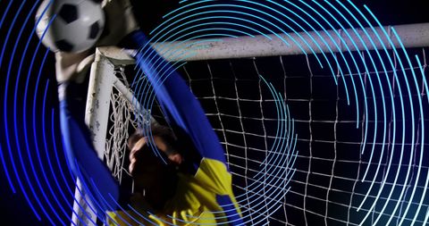 Goalkeeper saving ball with dynamic blue light effect