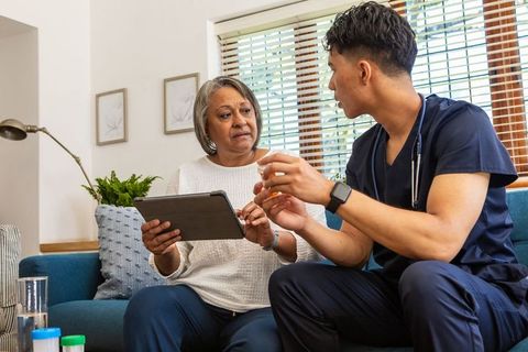 Nurse consultant discussing medication with senior at home