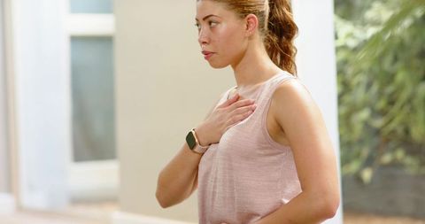 Woman practicing guided breathing with smartwatch and animated lungs overlay wellness routine
