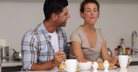 Happy Couple Enjoying Breakfast at Home in Kitchen
