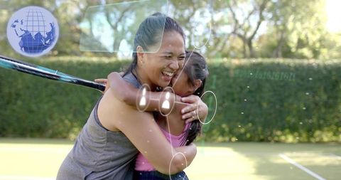 Mother and daughter hugging and laughing on tennis court with digital hud overlay