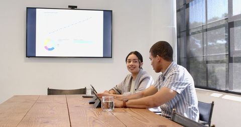 Multiracial colleagues discussing presentation in modern office