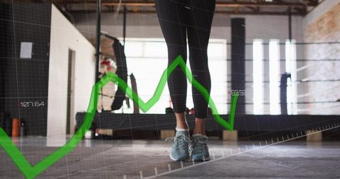 Standing woman on gym floor with green line graph overlay illustrating fitness analytics