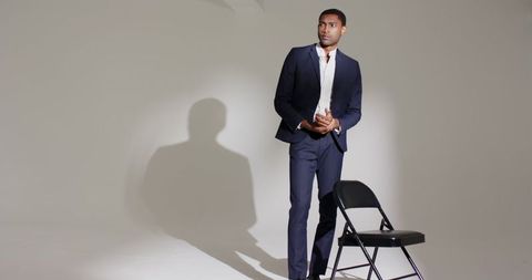 Confident businessman in navy suit in minimalist studio