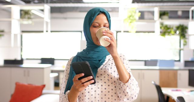 Muslim Woman Drinking Coffee in Modern Office While Using Smartphone - Download Free Stock Images Pikwizard.com