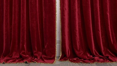 Opulent red velvet drapes with gold fringe revealing narrow white panel for dramatic interiors