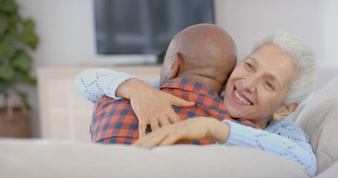 Happy Senior Couple Embracing on Couch at Home - Download Free Stock Images Pikwizard.com