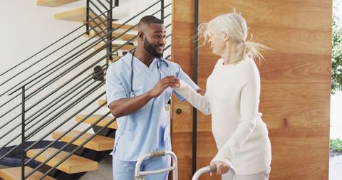 Caring nurse assisting elderly woman with mobility aid