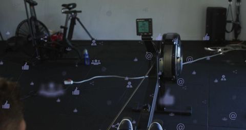 Rower pulling ergometer handle on indoor machine with fitness monitor and social media overlays
