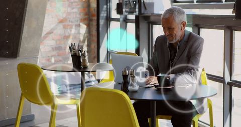 Caucasian Businessman Using Laptop with Digital Icons Overlay