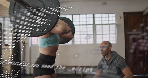 Female athlete performing front squat under coach supervision in industrial gym