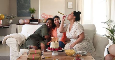Friends Celebrating Birthday on Cozy Sofa with Cake and Balloons