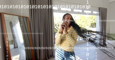 Joyful woman dancing home holding smartphone bright living room