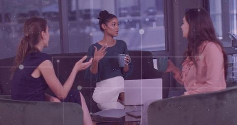 Businesswomen Exchanging Ideas Over Coffee in Office Lounge