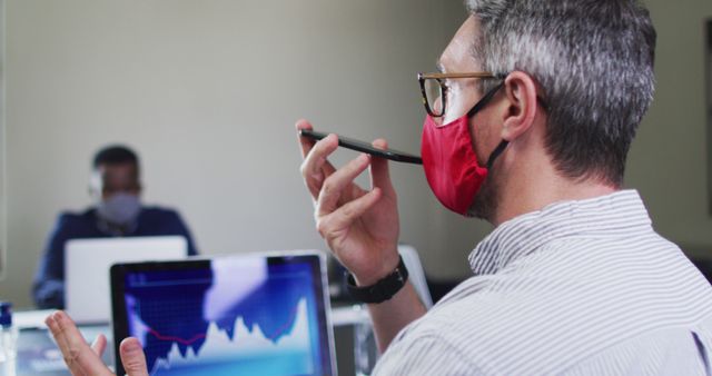 Businessman Wearing Mask Analyzing Financial Data in Office - Download Free Stock Images Pikwizard.com