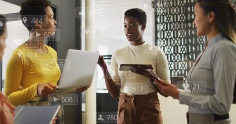 Professional Women Collaborating with Digital Analytics in Modern Office