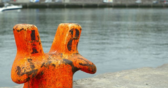 Close-up of weathered orange bollard by waterfront - Download Free Stock Images Pikwizard.com