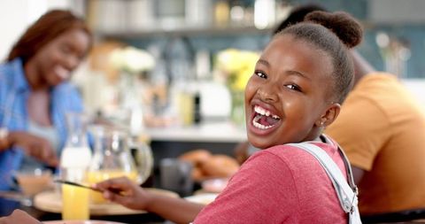 Happy Girl Enjoying Family Meal at Cozy Home Kitchen