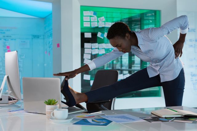 Female executive stretching at her desk in a futuristic office. Ideal for illustrating workplace wellness, office fitness, and modern work environments. Useful for articles on corporate health, productivity, and work-life balance.
