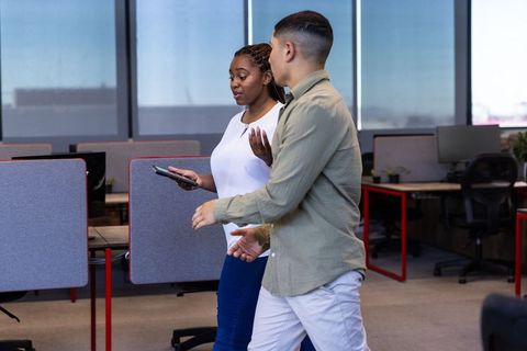Diverse Coworkers Walking and Talking in Modern Office