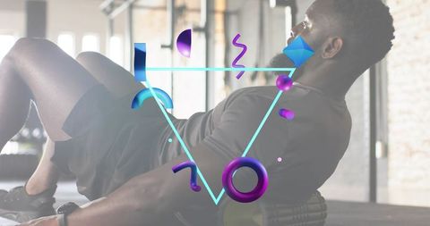 Black athlete using foam roller for mobility with neon geometric overlay in industrial gym