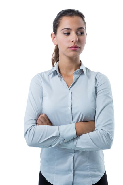 This image features a thoughtful female executive standing with her arms crossed against a white background. She is dressed in professional office attire, conveying a sense of confidence and seriousness. This image can be used in corporate presentations, business websites, leadership articles, and marketing materials to depict professionalism, decision making, and leadership qualities.