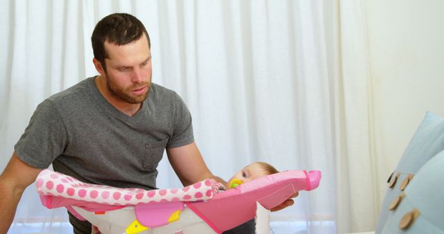 Father supervising infant in baby carrier at home - Download Free Stock Images Pikwizard.com