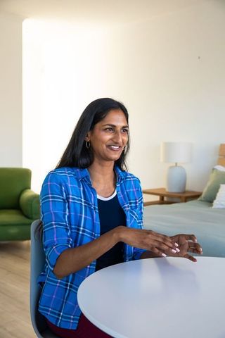 Woman in Plaid Shirt Communicating in Cozy Bedroom Living Area
