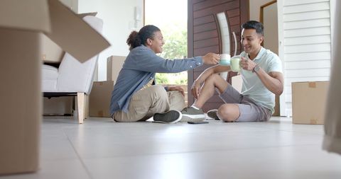 Happy Diverse Couple Celebrating New Home with Coffee