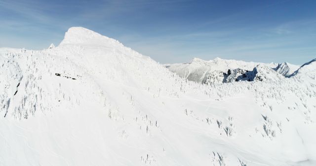 Aerial view of a snow-covered mountain under a clear blue sky - Download Free Stock Photos Pikwizard.com