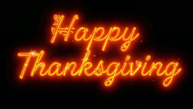 Neon Happy Thanksgiving Cursive Sign with Warm Orange Glow and Leaf Accents