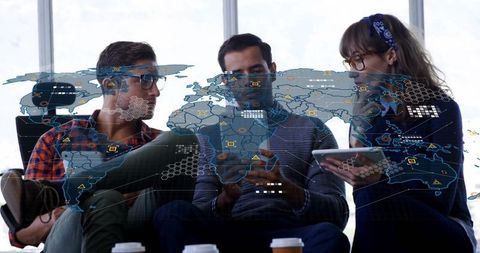 Professionals discussing data on digital world map overlay